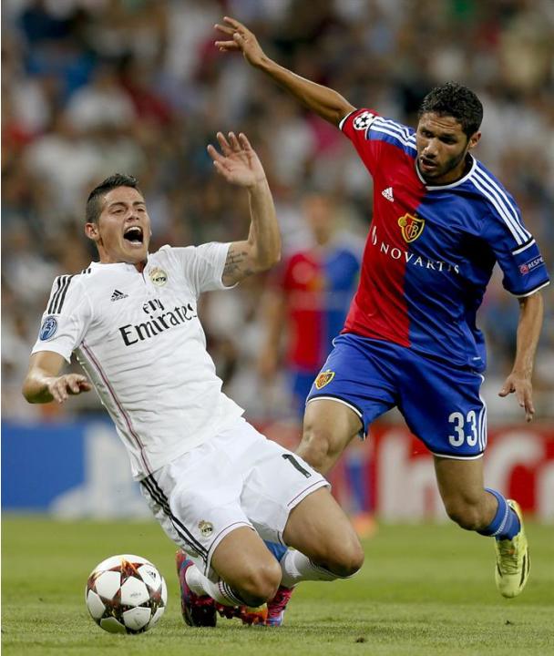 GRA585. MADRID. 16/09/2014.- El centrocampista colombiano del Real Madrid James Rodríguez (d) lucha el balón con el centrocampista egipcio Mohamed Elneny (i), del FC Basilea, durante el partido de la 