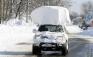 A vehicle, with a large chunk of snow on its top, drives along Route 20 after digging out after a massive snow fall in Lancaster, N.Y. Wednesday, Nov. 19, 2014. Another two to three feet of snow is expected in the area. (AP Photo/Gary Wiepert)