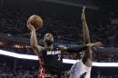 Dwayne Wade, del Heat de Miami, ataca la canasta ante Al Jefferson (25) y Kemba Walker (15) de los Bobcats de Charlotte durante la primera mitad del tercer juego de su serie de playoffs el sábado 26 de abril de 2014 en Charlotte. (AP Photo/Chuck Burton)