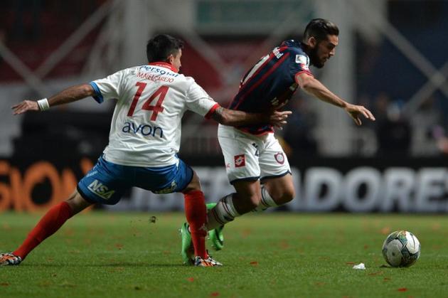 BAS08.  BUENOS AIRES (ARGENTINA), 13/08 / 2014.- El jugador de San Lorenzo Emmanuel Mas (d) SUPERA La Marca de Marcos Melgarejo (i), de Nacional, hoy, miércoles 13 de agosto de 2014, Durante el partido p