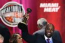 El ex basquetbolista Alonzo Mourning levanta su trofeo tras ser exaltado al Salón de la Fama del básquetbol el viernes, 8 de agosto de 2014, en Springfield, Massachusetts. (AP Photo/Charles Krupa)