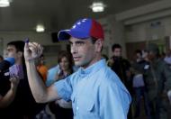 Venezuelan opposition leader Henrique Capriles shows his ink-stained finger after casting his vote at a polling station during a legislative election, in Caracas December 6, 2015. REUTERS/Marco Bello