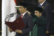 Indonesian President Joko Widodo, center, reads his oath during his inauguration ceremony as the country's seventh president at the parliament building in Jakarta, Indonesia, Monday, Oct. 20, 2014. (AP Photo/Dita Alangkara)