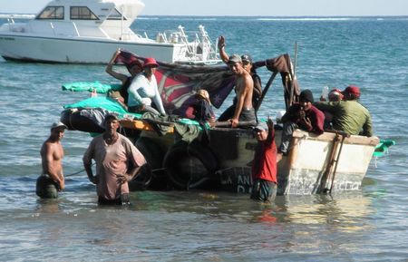 Fifteen Cuban migrants prepare to set sail in their 14-foot homemade boat after a brief overnight stop offshore Grand Cayman Island, November 21, 2014. REUTERS/Peter Polack