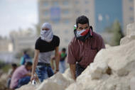 Palestinian demonstrators take cover during clashes with Israeli troops near Ramallah, West Bank, Tuesday, Sept. 29, 2015. Palestinian demonstrators clashed with Israeli troops across the West Bank on Tuesday as tensions remained high following days of violence at Jerusalem’s most sensitive holy site, revered by Jews as the Temple Mount and by Muslims as the Noble Sanctuary. (AP Photo/Majdi Mohammed)