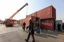 A Frontier Constabulary personnel walks past a   container, which will be used to block roads during a planned protest called by   political party Pakistan Tehreek-e-Insaf in Islamabad