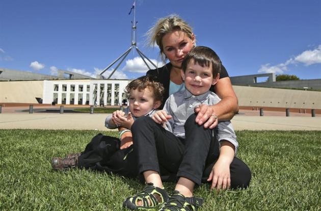 FILE - In this March 5, 2015 file photo, Danica Weeks, whose husband Paul was aboard Malaysia Airlines Flight 370, poses for a photo with her sons Lincoln, 4, front right and Jack,1, outside the Australia Parliament House in Canberra, Australia. Amid mounting frustrations over the expensive, so-far failed search for vanished Malaysia Airlines Flight 370, questions by experts about the competence of the company leading the search are growing, including whether crews may have passed over the sunken wreckage without even noticing. Weeks trusts that the company Fugro knows what it is doing. But she also wants the data reviewed in case a crucial clue was missed. [AP Photo/Rob Griffith, File)