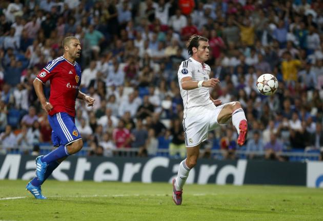 Real Madrid's Gareth Bale kicks to score next to FC Basel's Walter Samuel during their Champions League soccer match at Santiago Bernabeu stadium in Madrid