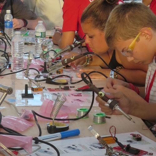 Children building circuit boards at Maker Faire