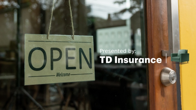 View of an Open sign hanging in the window of a shop with a Presented By TD logo over top