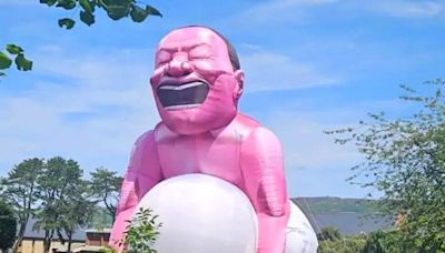Giant inflatable pink man suddenly pops up in tiny town
