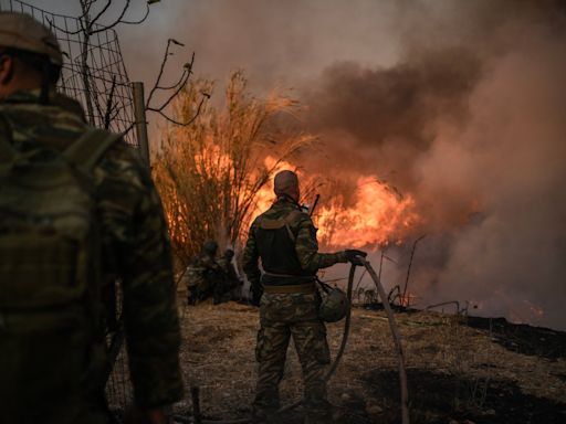 Greece wildfires - latest: Athens seaside town evacuated as strong winds spread deadly fire