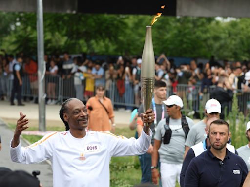 Snoop Dogg carries the Olympic torch before opening ceremony in Paris