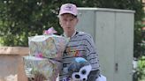 Machine Gun Kelly carries presents as he departs toy store