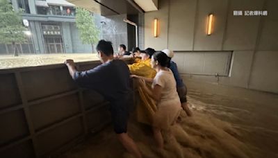 一二三合力擋！暴雨狂灌停車場住戶力撐防水門