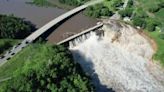 Building swept away by water after dam’s ‘partial’ failure