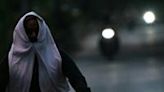 A man riding a motocycle covers his face with cloth on a hot summer evening near Mungeshpur, a suburb in New Delhi on May 29