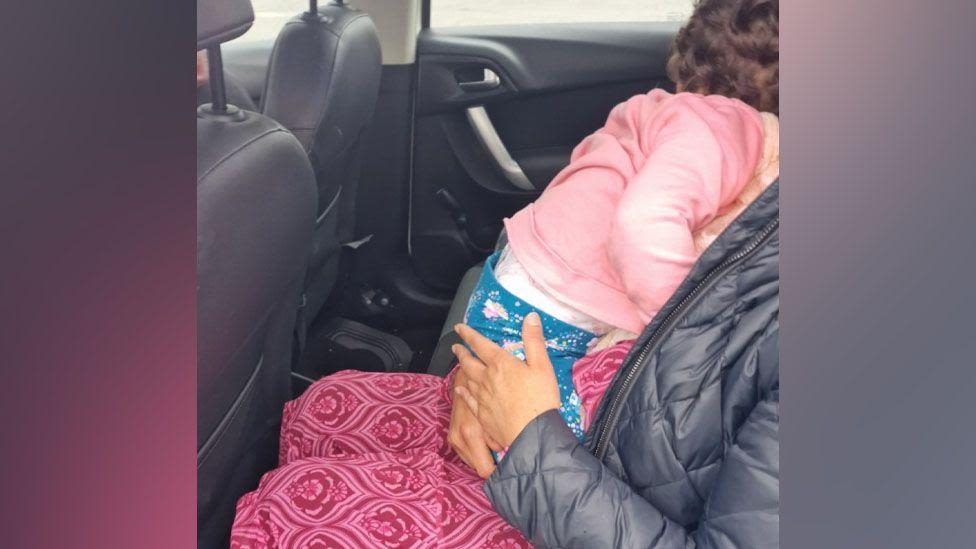 Toddler asleep on passenger's knee with no seatbelt