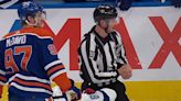 NHL on-ice official seriously injured when he got caught in the crossfire of a pair of cheap shots