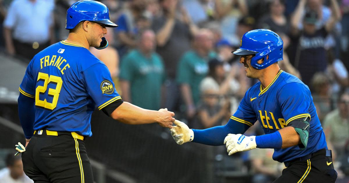 The Seattle Mariners' Dylan Moore, right, celebrates with teammate Ty France after hitting a two-run home run during the fourth inning against the Oakland Athletics at T...