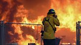 Firefighters seek relief from cold temperatures after the Park Fire, California's largest wildfire, erupts