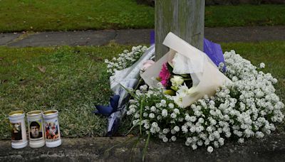 Flowers and candles left at home where three children died in fire