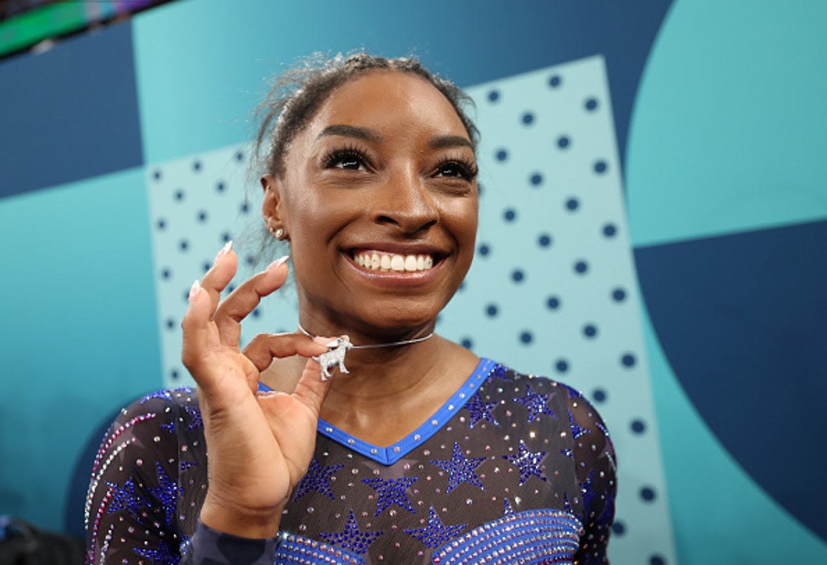 Simone Biles celebrates her gold medal with a diamond goat necklace