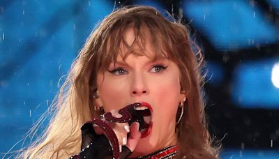 Taylor Swift performs in the RAIN and helps fan during Lyon tour stop