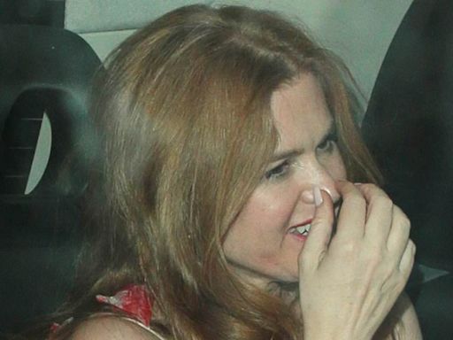 Isla Fisher looks giddy as she gets into awaiting car after event