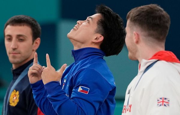 Filipino gymnast who won 2 Olympic golds in Paris gets hero's welcome and free buffets for life