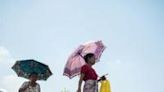 Women walk under umbrellas to shelter from the sun on a hot day in Yangon, as authorities issue extreme heat warnings across South and Southeast Asia