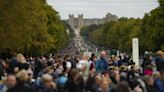 Windsor crowds sing national anthem as they await arrival of Queen’s coffin