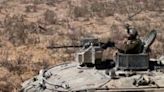 Israeli soldiers man an armoured vehicle operating near the border with the Gaza Strip