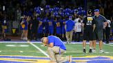 A thankful Kennedy takes a knee after return to Bremerton football field