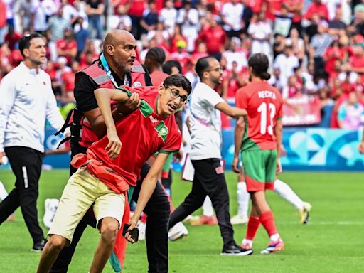 Olympic football off to violent, chaotic start as Morocco fans rush the field in team's stunning win over Argentina