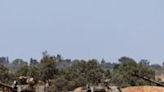 Israeli troops man a position with mobile artillery units in southern Israel near the border with the Gaza Strip