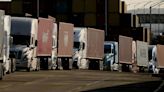 Trucks carrying cargo containers line up at the Port of Los Angeles in July 2023. California is waiting for the EPA approve a rule that would hasten...