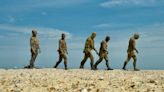 Beach welcomes giant sculpture of five walking men