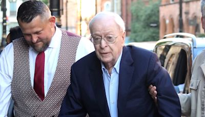 Michael Caine pushes a walker while arriving for dinner at The Ivy