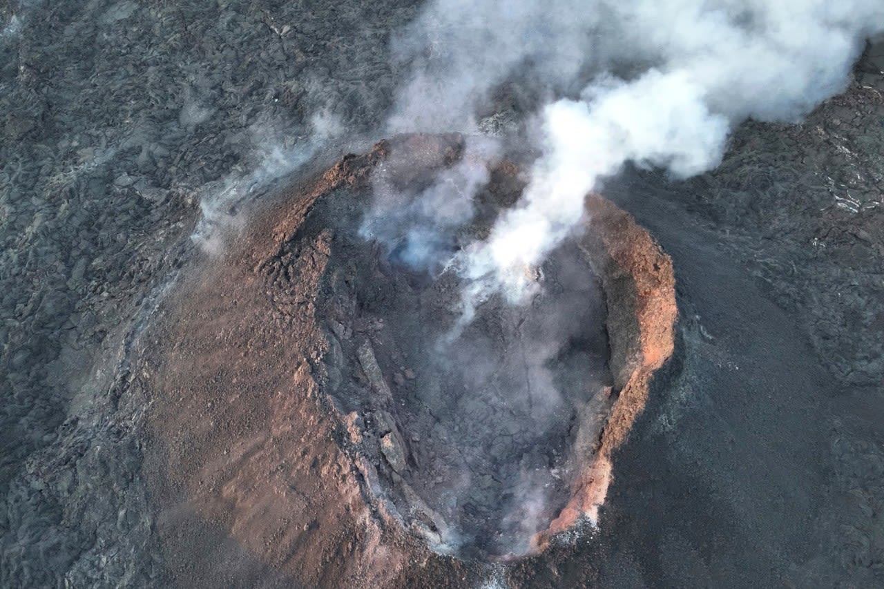 An Iceland volcano spews red streams of lava toward an evacuated town