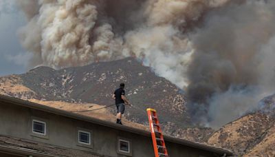 Residents flee as California and Nevada wildfires get dangerously close and forecasters warn of record heat