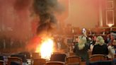 Albania's opposition disrupts a budget vote with flares and piled-up chairs in Parliament