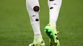 Why do England football players cut holes in their socks?