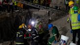 Rescuers bring out survivors from the rubble a day after a deadly building collapse in South Africa