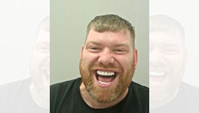 Man smiling and laughing in mugshot wanted over drug supply