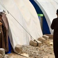 Children stand by tents in April 2024 at the Al-Jadaa camp south of Mosul which houses Iraqi families who have been repatriated from Syria's Al-Hol camp