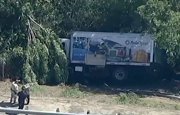 Worker killed, another injured, when truck crashes through guardrail along California freeway