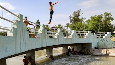 Iraqis flock to river or ice rink to escape searing heat