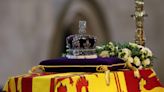 Imperial State Crown and royal scepter glimmer, but some say on back of colonialism