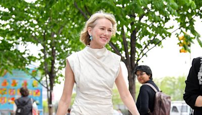 Naomi Watts, 55, cuts a youthful figure in a chic cream frock